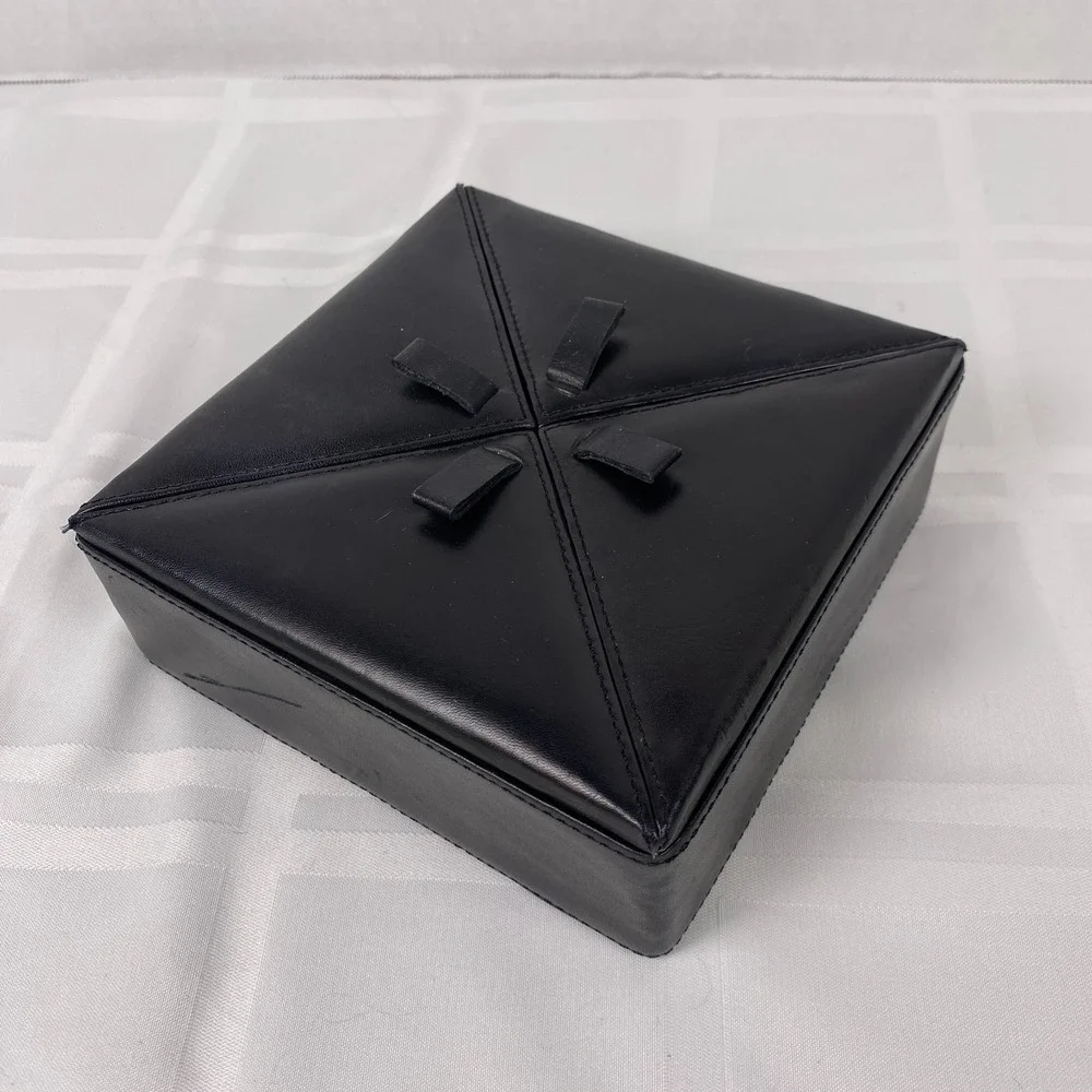Black Leather-covered box with a‎ padded stitched lid divided into for panels